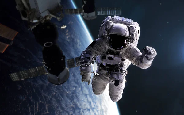 Astronauta na caminhada espacial com estação espacial em segundo plano. Elemento — Fotografia de Stock