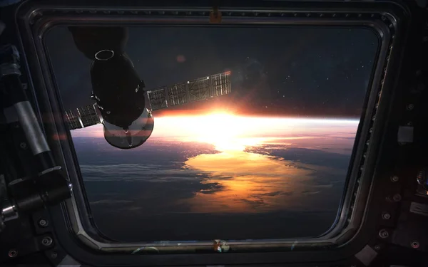 Regarde le lever du soleil depuis la fenêtre de la station spatiale. Éléments de cette — Photo