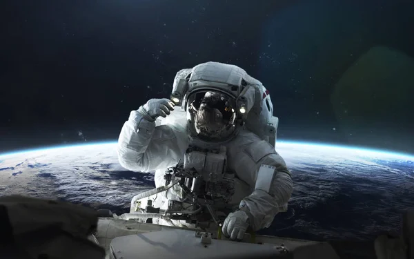 O astronauta repara a estação espacial na órbita do planeta Terra. Elementos — Fotografia de Stock