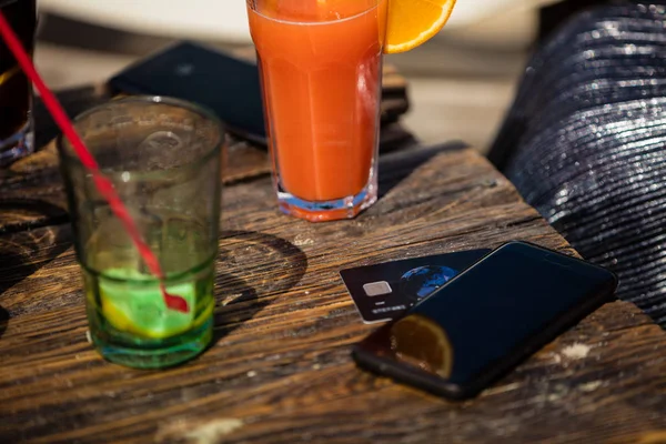 Oranje cocktail en credit card op strandbar — Stockfoto