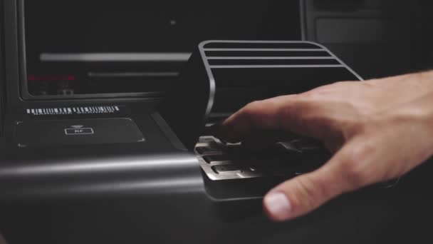 Personne entrant le code PIN et retirant de l'argent de la machine ATM 