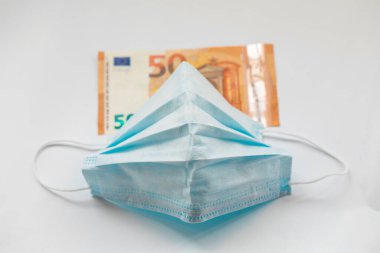 Coronavirus Covid-19 veya grip ve grip virüslerine karşı koruma maskesi. Kirli para banknotu beyaz arka planda izole.