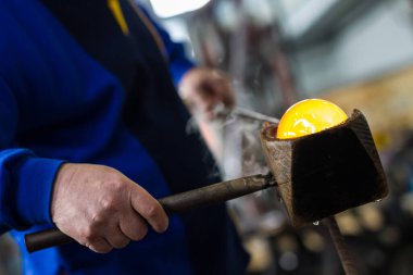 Cam üfleyici güzel bir cam parçası oluşturuyor. Bir cam ustası yanıyor ve bir sanat eserini üflüyor.. 