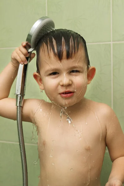 Happy little boy takes a shower in the bathroom — Stockfoto