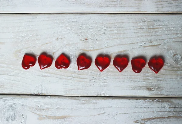 Ahşap beyaz arka planda birçok kırmızı kalpler — Stok fotoğraf