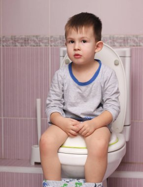 Küçük çocuk banyoda tuvalet oda üzerinde oturan