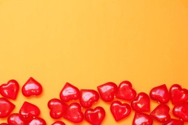 Çok sayıda sarı bir arka plan üzerinde kırmızı kalpler.