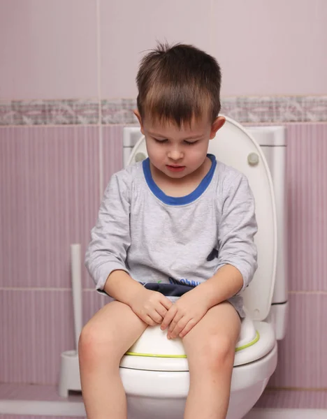 Niño pequeño sentado en el baño en el cuarto de baño — Foto de Stock