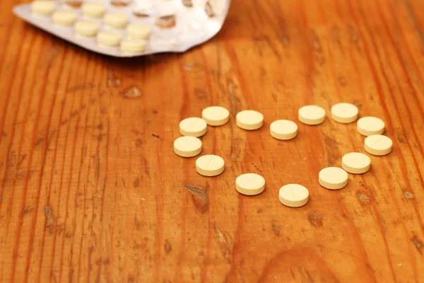 Kalp - tablet ahşap arka plan, uyuşturucu kavramı üzerinde — Stok fotoğraf