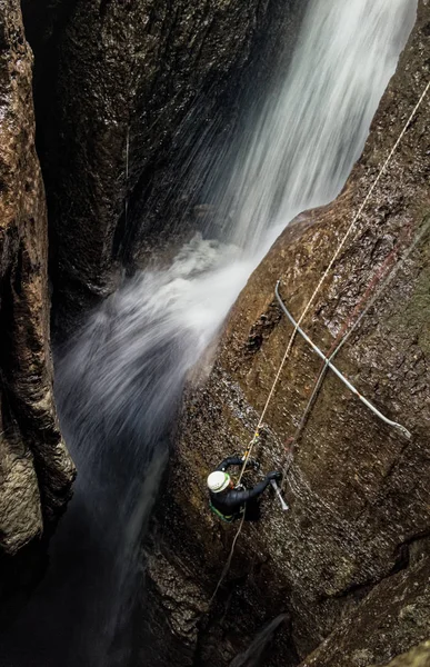 Espeleólogo y cascada subterránea — Foto de Stock