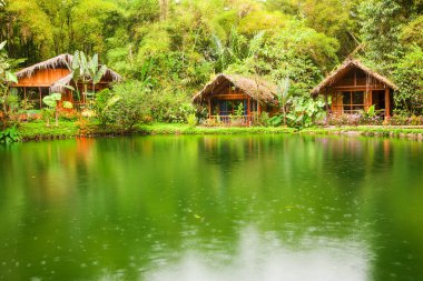 Yağmurlu mevsimde Gölün Önündeki Egzotik Kulübeler