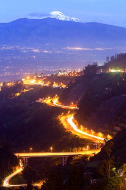 Arka planda El Antisana Volkanı ile Geceleyin Quito 'nun Ne' si