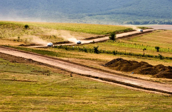 Três Carros Estradas Empoeiradas País Que Passam Através Campo Plantado — Fotografia de Stock