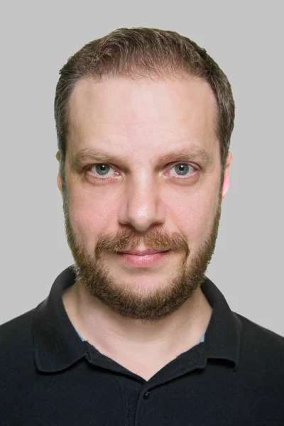 Портрет взрослого бородатого мужчины на сером фоне . — стоковое фото