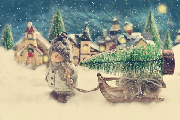 Vinter nattscen med en pojke som att dra en slad med julgran — Stockfoto