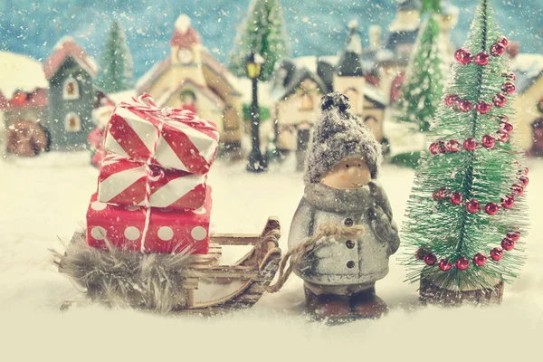 Escena del día de invierno con un niño tirando de un trineo con regalos de Navidad —  Fotos de Stock