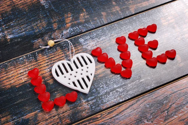 Das Wort Liebe aus roten Bonbons und weißem Herzen — Stockfoto