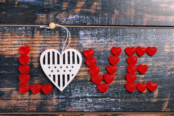 The word LOVE made of red candies and white heart — Stock Photo, Image