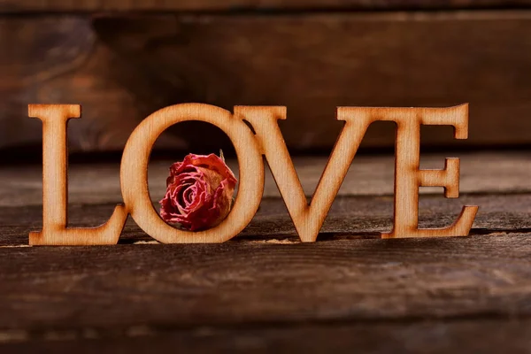 Parola di legno AMORE con rosa appassita — Foto Stock