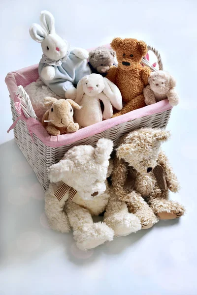 Plush teddy bears and bunnies in wicker basket — Stock Photo, Image