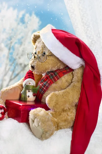 Christmas teddy bear sitting at the window in winter time — Stock Photo, Image
