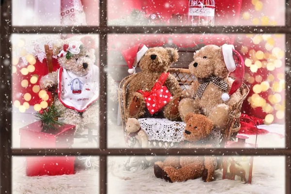 Zobrazit oknem medvídek rodině v době Vánoc — Stock fotografie