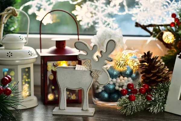 Рождественское украшение окон с деревянными оленями и старым фонарем — стоковое фото