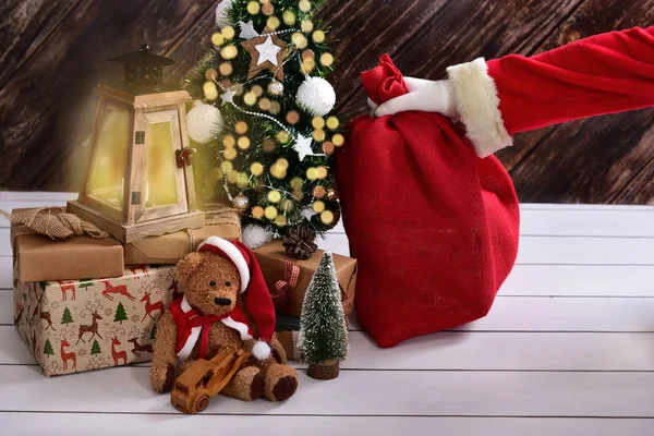 Santa claus tajně uvedení pytel dárek pod vánoční stromeček — Stock fotografie