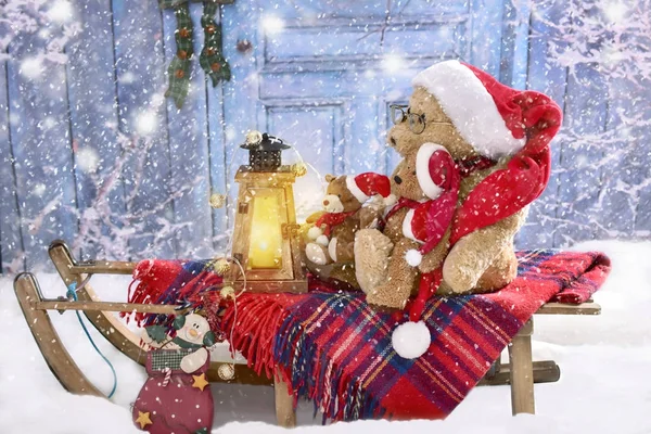 Teddy bears in santa hats sledding in snowy evening — Stock Photo, Image