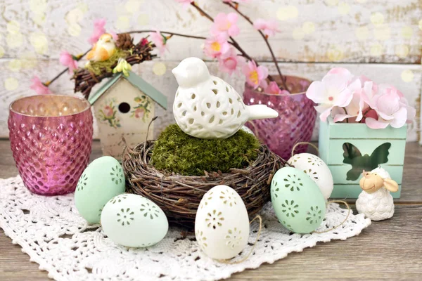 Easter decoration with porcelain bird in nest and eggs — Stock Photo, Image