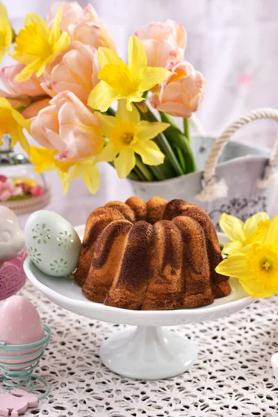 Húsvéti ünnepi asztal, márvány gyűrű torta és a díszek — Stock Fotó