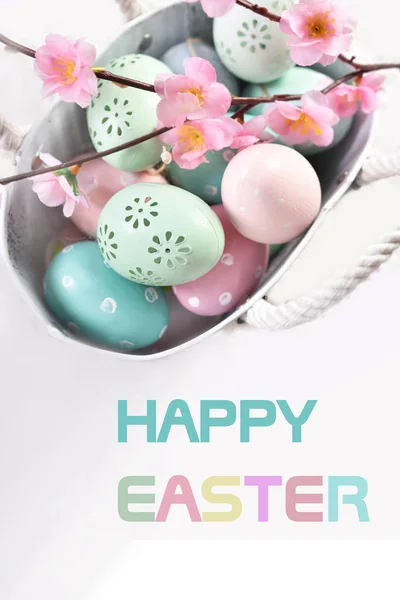 Ostergrußkarte mit Text und bunten Eiern im Metallkorb — Stockfoto
