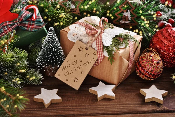 Christmas present in rustic style with greeting text on paper la — Stock Photo, Image