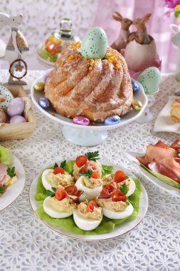 Sebze salatasıyla doldurulmuş yumurtalarla Paskalya kahvaltısı ve festival masasında halka kek.