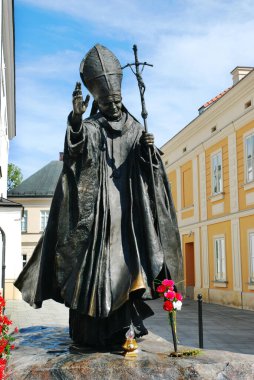 Monument of the pope John Paul II located next to the Basilica of the Holy Mary and the house where he was born in Wadowice clipart