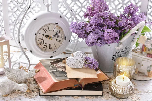 紫のライラックの花 写真や引き出しの胸に立っている古い時計の束とヴィンテージスタイルの家の装飾 — ストック写真