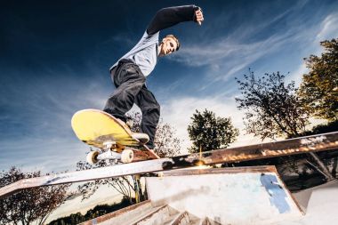 Genç skater bir eziyet Skatepark üzerinde günbatımı sırasında yapma.
