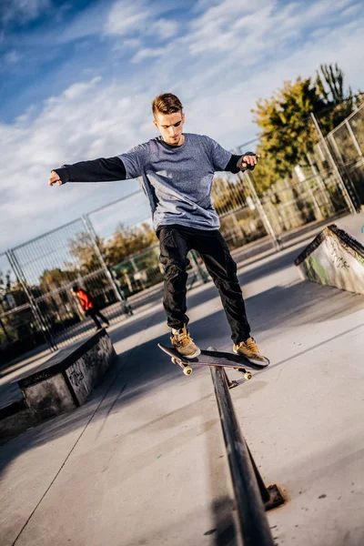 Joven patinador haciendo un Grind en Skatepark Fotos de stock