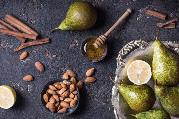 Fresh green pears in the old vintage tray with almond nuts, lemon, honey and cinnamon — Stock Photo, Image