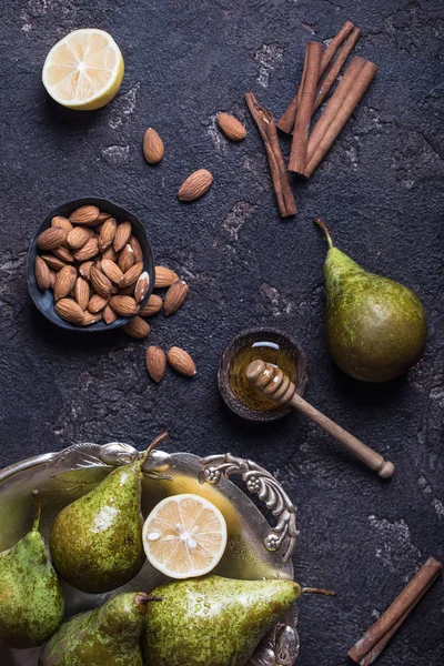 Fresh green pears in the old vintage tray with almond nuts, lemon, honey and cinnamon — Stock Photo, Image