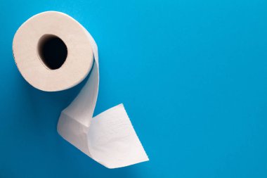 Mavi arka planda tuvalet kağıdı ve mesaj için boş oda. Düz yatıyordu. Üst görünüm