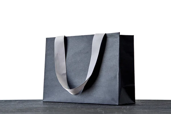 A studio photo of a black gift bag