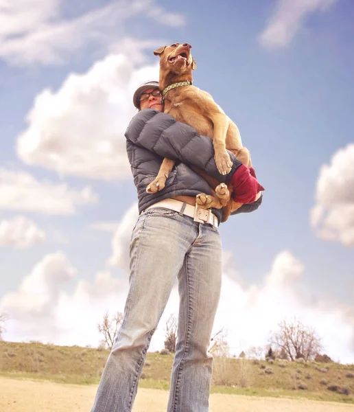 Una chica sosteniendo a su gran perro en sus brazos — Foto de Stock