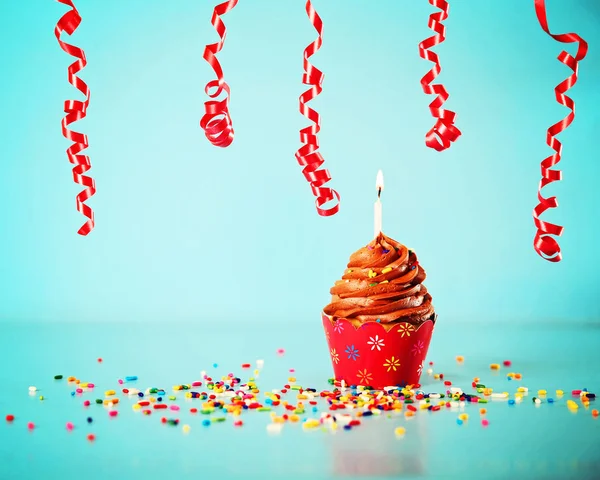 Cupcake de aniversário de chocolate com streamers — Fotografia de Stock