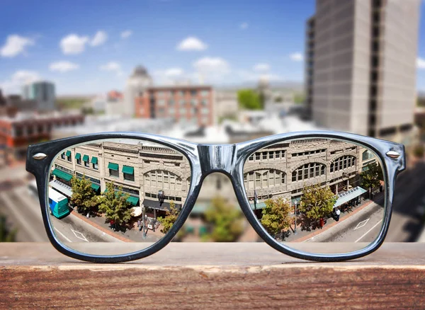 Gafas hipster en un banco del parque con un paisaje urbano —  Fotos de Stock