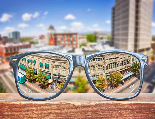 Hipster-Brille auf einer Parkbank mit Stadtbild — Stockfoto