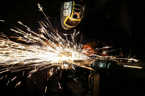 A guy in welding helmet and gear grinding metal — Stock Photo, Image