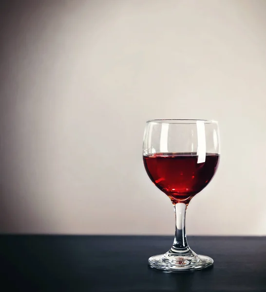 Rotwein im Glas auf dunklem Tisch — Stockfoto