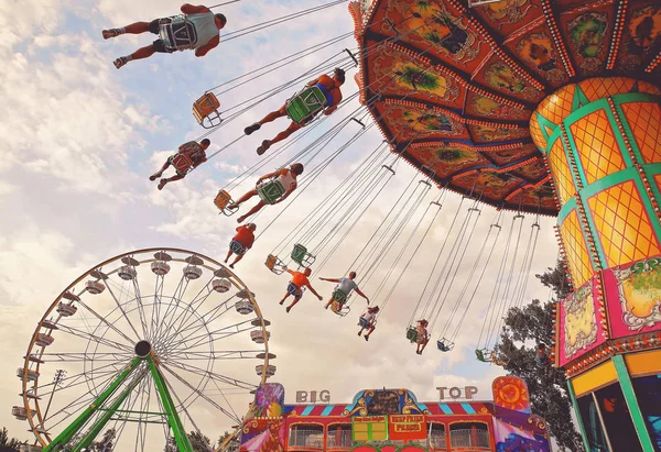 People riding rides and enjoying the summer atmosphere at a stat — Stock Photo, Image