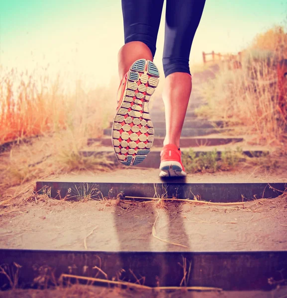 En kvinna med en atletisk par ben gå för en joggingtur eller köra dur — Stockfoto